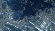 Satelliittikuvassa näkyvät laajat mustat savupilvet, jotka nousevat palavista öljyvarastoista.
