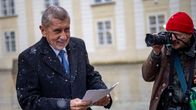 Andrej Babis pitää papereita kädessään lumisateessa, pipopäinen valokuvaaja kuvaa häntä.