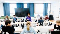 Venla Bernelius of the ministry's working group talks to a classroom of children.