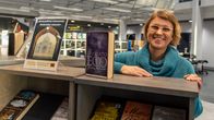 Malin Hollmén vid en bokhylla.