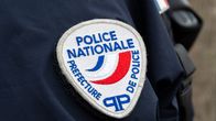 Poliisin tummansiniseen takkiin ommeltu pyöreä Police Nationale -merkki.