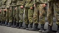 Beväringar iklädda marschkängor upställda i en korridor. 