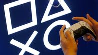 Henkilö pitää peliohjainta kädessään PlayStationin symbolien edessä.