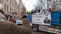Nainen vilkuttaa abeille, jotka ovat auton lavalla.