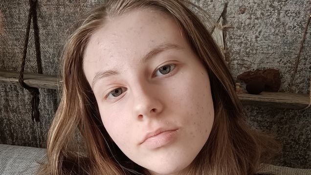 Kuvassa on nuori, joka on itse kuvannut itsensä edestä päin. Hänellä on pitkät hiukset ja intensiivinen katse.