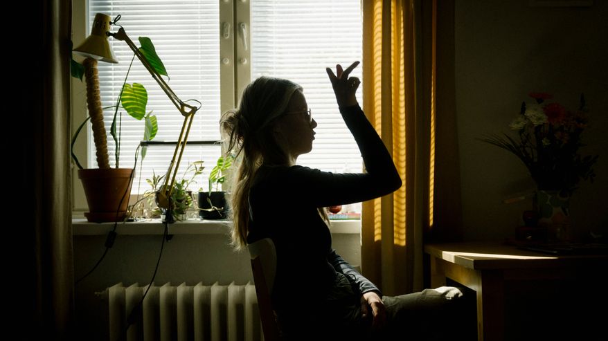 Ida Sivonen istuu kotonaan.