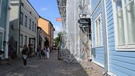 Vanhan kaupungin mukulakivikadulla kuljetaan ohi remontissa olevan puutalon.