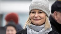 Riikka Purra (ps.) hymyilee ihmisjoukon keskellä.