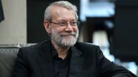 Hymyilevä Ali Larijani istuu mustassa pikkutakissa ja mustassa kauluspaidassa harmaassa nojatuolissa. Hänellä on silmälasit ja harmaantunut parta.