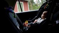 Vauva istuu turvaistuimessa auton takapenkillä.