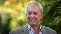 Mario Vargas Llosa harmaassa pikkutakissa taustallaan lehvästöä auringonpaisteessa.