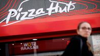 Nainen kävelee Pizza Hut -ravintolan ohi.