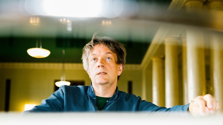 Teemu Keskisarja istuu eduskuntatalon kahvilan pöydän ääressä.