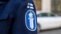 Poliisin virkapuvun tunnus ja Suomen lippu takin hihassa.