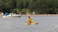 Strandräddare sitter på ett surfbräde.