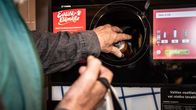 A person inserts a bottle into a recycling machine.