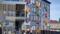 Immalan loisteessa ihmiset laulavat parvekkeilla ja terassilla.