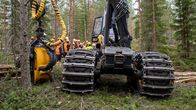 Hakkuualueella vierailijoita metsäkoneen luona.