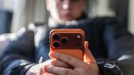 A young person holding an iPhone 17 mobile phone in their hands.