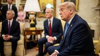 Kaksi ihmistä keskustelee Valkoisessa talossa presidentti Trumpin kanssa.