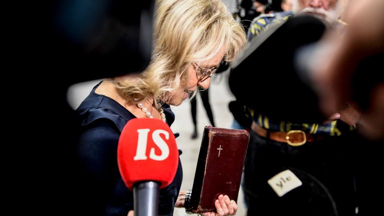 Päivi Räsänen käräjäoikeuden aulassa Raamattu kädessään.