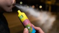 Värikäs Vape kädessä ja suusta tulee höyryä.