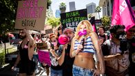 Mielenosoittajia kadulla kyltteineen, mukana myös iso pahvikuva Britney Spearsista
