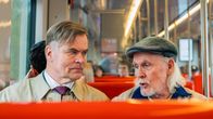 Two men sit on a metro bench.