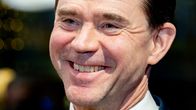 Jyrki Katainen nauraa sinisessä puvussa.