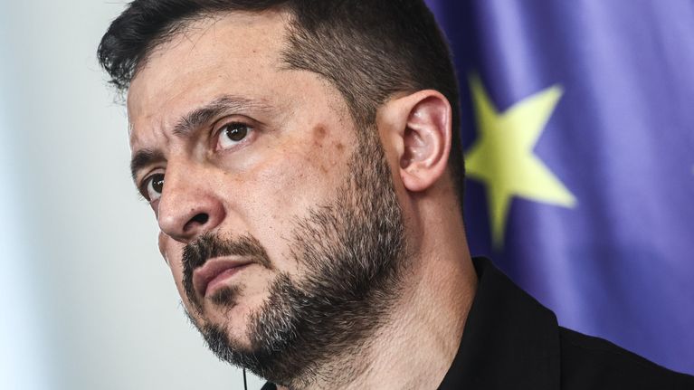Volodymyr Zelenskyi tiedotustilaisuudessa taustalla näkyy hieman EU-lippua.