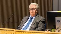 Vakavailmeinen Kalervo Kummola istuu pöydän takana.