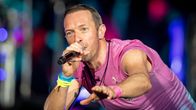 Chris Martin laulaa mikkiin lavalla. 