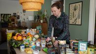 Linda Hästbacka asettelee elintarvikkeita pöydälle. 
