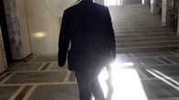 The back of a person walking down the halls of Parliament. 