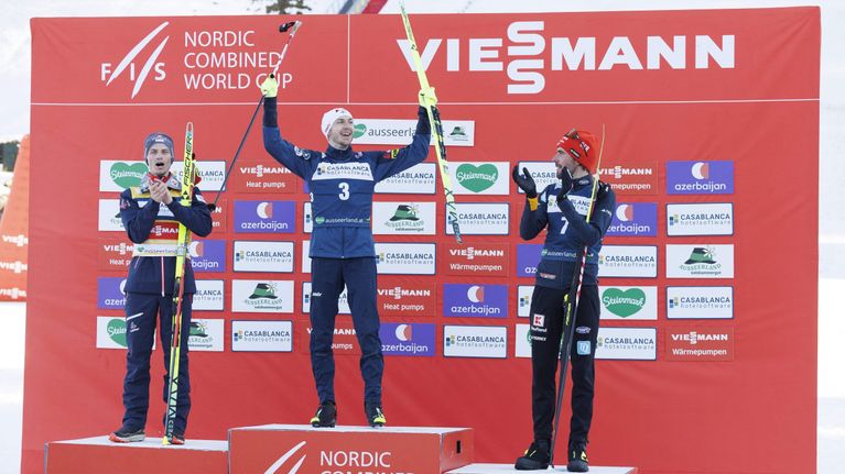Ilkka Herola tuulettaa palkintokorokkeella voittoaan. Vasemmalla puolella Johannes Lamparter, oikealla puolella Johannes Rydzek.