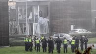 Poliiseja seisomassa räjähdyksessä vaurioituneen talon edessä. 