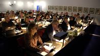 Kouvolan kaupunginvaltuuston valtuutetut istuvat paikoillaan valtuustosalissa. Moni katsoo kohti etuvasempaa.