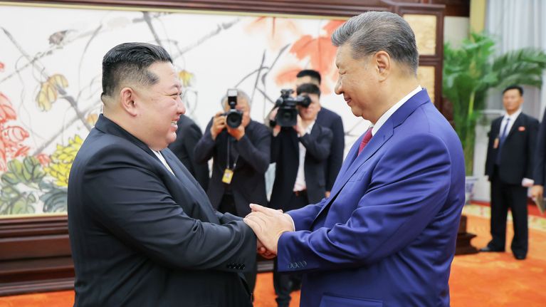 Kim Jong-un ja Xi Jinping kättelevät.