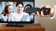 Netflixin ohjelma kuvaruudulla, kaukosäätimellä säätöä. Anonyymi.