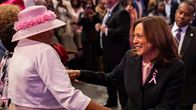 Kamala Harris och en dam i rosa hatt.