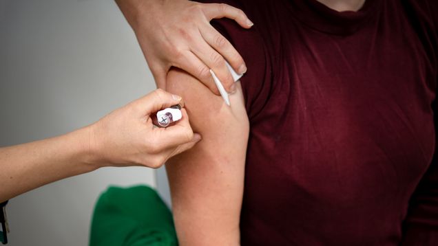 A person receiving a vaccination in their upper arm.