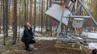Hannakaisa Lindqvist taustallaan metsää ja tutkimuslaitteita.