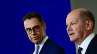  Alexander Stubb katsoo Olaf Scholzia kohti. Tausta sininen.