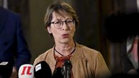 Sari Essayah (KD) vid ett podium med mikrofoner.