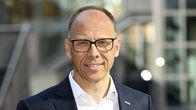 Frank Vang-Jensen hymyilee kameraan puku päällä, valkoisessa paidassa, ilman kravattia.