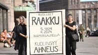 Mustiin pukeutuneet mielenosoittajat kantavat kylttiä, jossa lukee: Kuolleet, Raakku. s. 1824, k. 2024 Suomussalmella, kuolinsyy: Ahneus.
