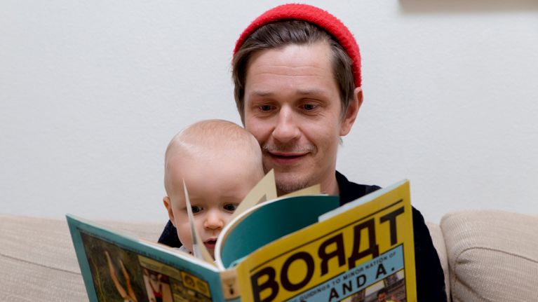 Isä Edu Kehäkettunen ja poika Ivan Hinkkanen katselevat kirjaa yhdessä.