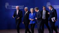 Herman Van Rompuy, Antonio Costa, Ursula von der Leyen, Donald Tusk, Petteri Orpo kävelevät keskustellen punaisella matolla takana sininen seinä, jossa Eurooppa-neuvoston logo.