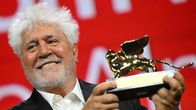 Pedro Almodovar håller leende upp sin prisstatyett.
