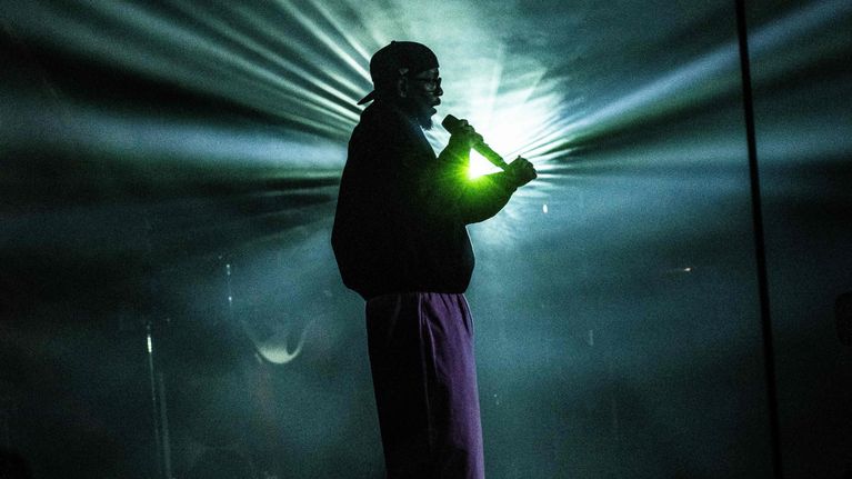 Kendrick Lamar esiintymässä mikrofonia pidellen.